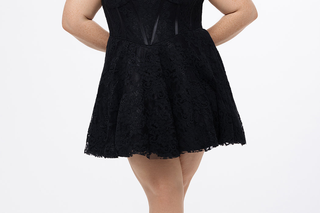 Celebrations by Sydney's Closet Style CE2612 in black. 

Plus size strapless black short mini party dress with sweetheart neckline, exposed corset boning on bustier bodice and mini skirt in all over stretch lace. 