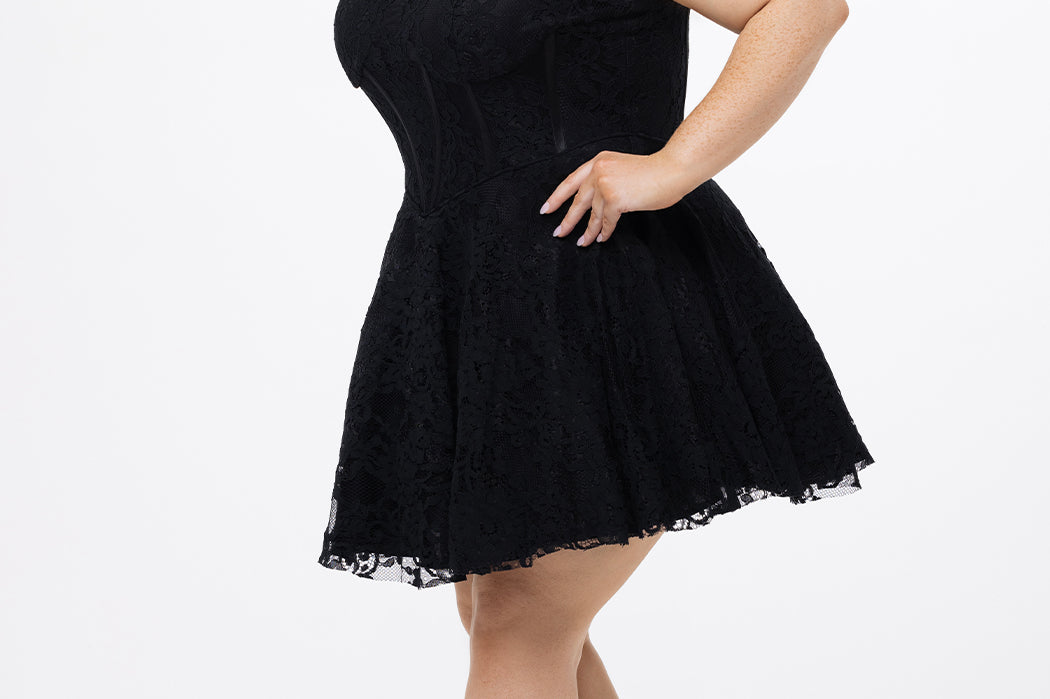 Celebrations by Sydney's Closet Style CE2612 in black. 

Plus size strapless black short mini party dress with sweetheart neckline, exposed corset boning on bustier bodice and mini skirt in all over stretch lace. 