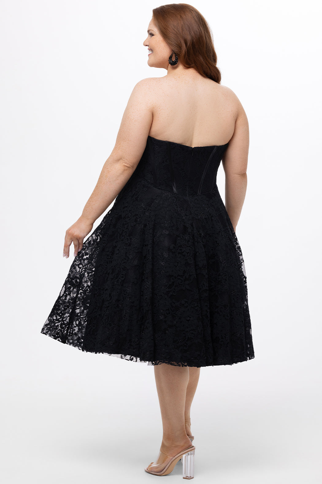 Celebrations by Sydney's Closet Style CE2613 in black. 

Plus size strapless black tea-length dress with sweetheart neckline, exposed corset boning on bustier bodice and tea-length skirt in all over stretch lace. 