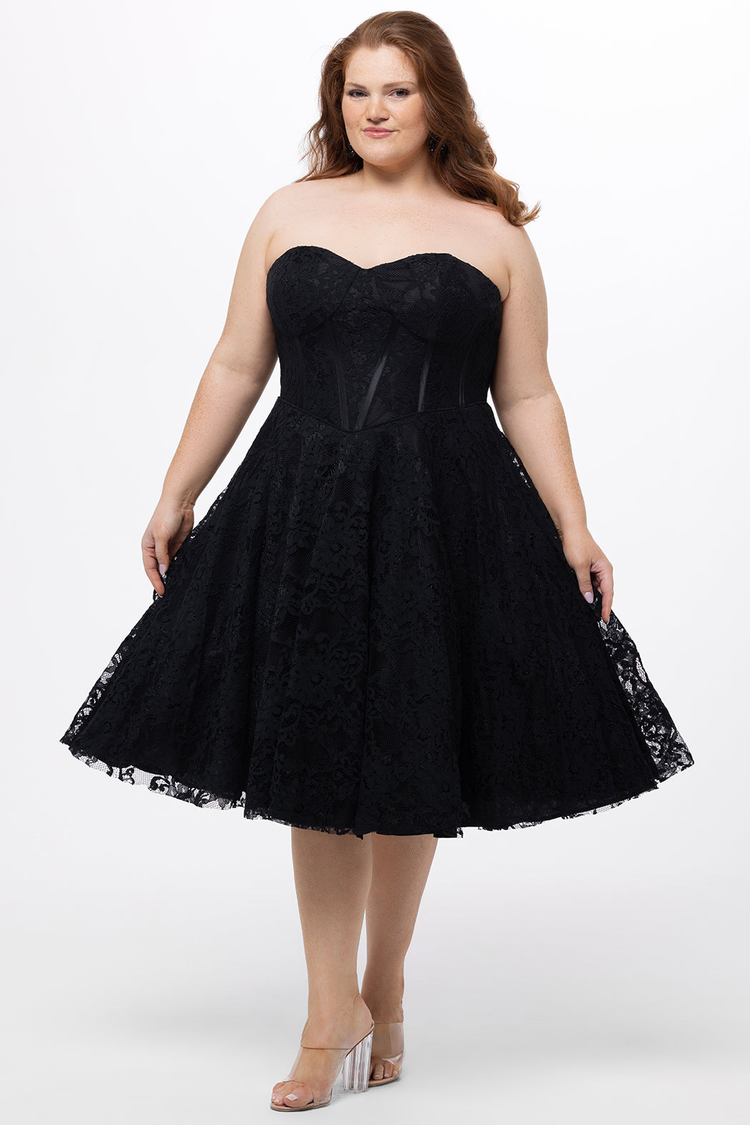 Celebrations by Sydney's Closet Style CE2613 in black. 

Plus size strapless black tea-length dress with sweetheart neckline, exposed corset boning on bustier bodice and tea-length skirt in all over stretch lace. 