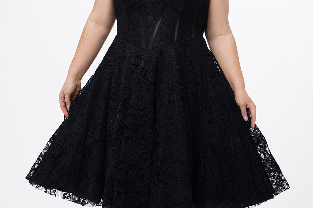 Celebrations by Sydney's Closet Style CE2613 in black. 

Plus size strapless black tea-length dress with sweetheart neckline, exposed corset boning on bustier bodice and tea-length skirt in all over stretch lace. 