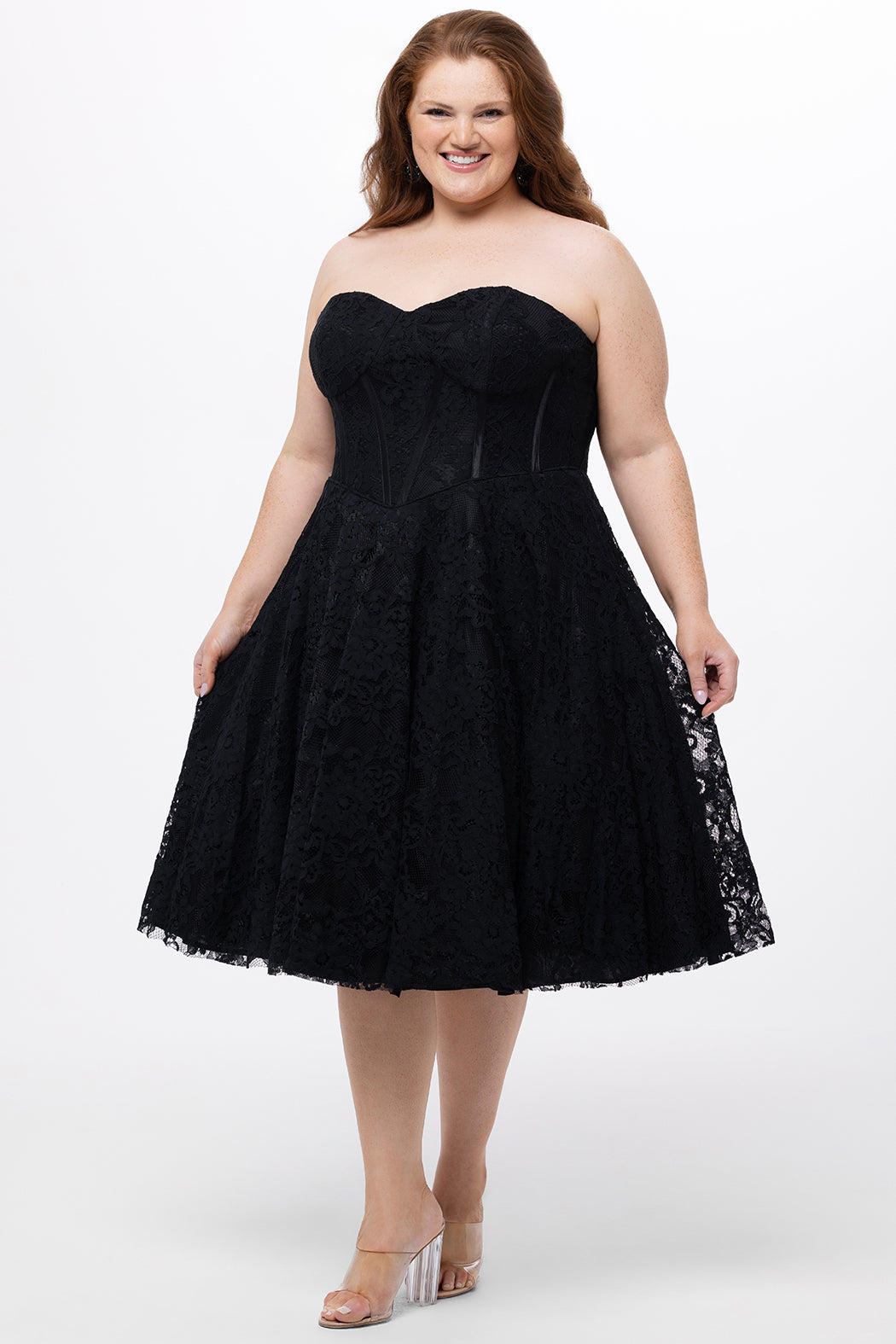 Celebrations by Sydney's Closet Style CE2613 in black. 

Plus size strapless black tea-length dress with sweetheart neckline, exposed corset boning on bustier bodice and tea-length skirt in all over stretch lace. 