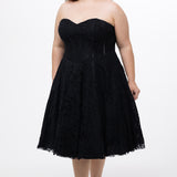 Celebrations by Sydney's Closet Style CE2613 in black. 

Plus size strapless black tea-length dress with sweetheart neckline, exposed corset boning on bustier bodice and tea-length skirt in all over stretch lace. 