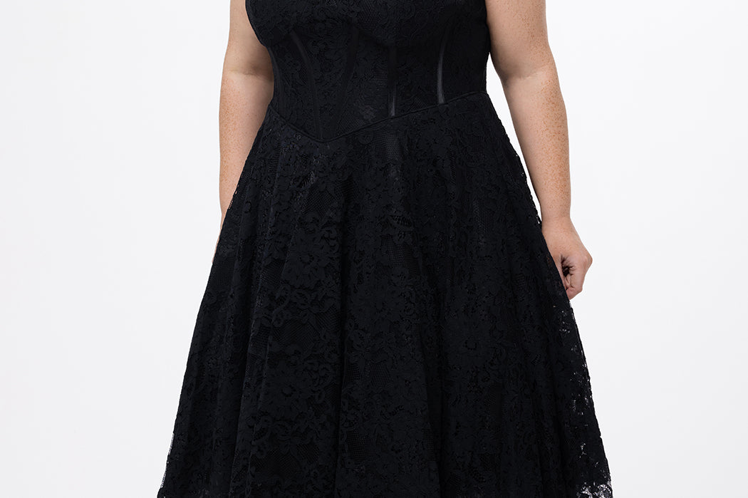 Celebrations by Sydney's Closet Style CE2613 in black. 

Plus size strapless black tea-length dress with sweetheart neckline, exposed corset boning on bustier bodice and tea-length skirt in all over stretch lace. 