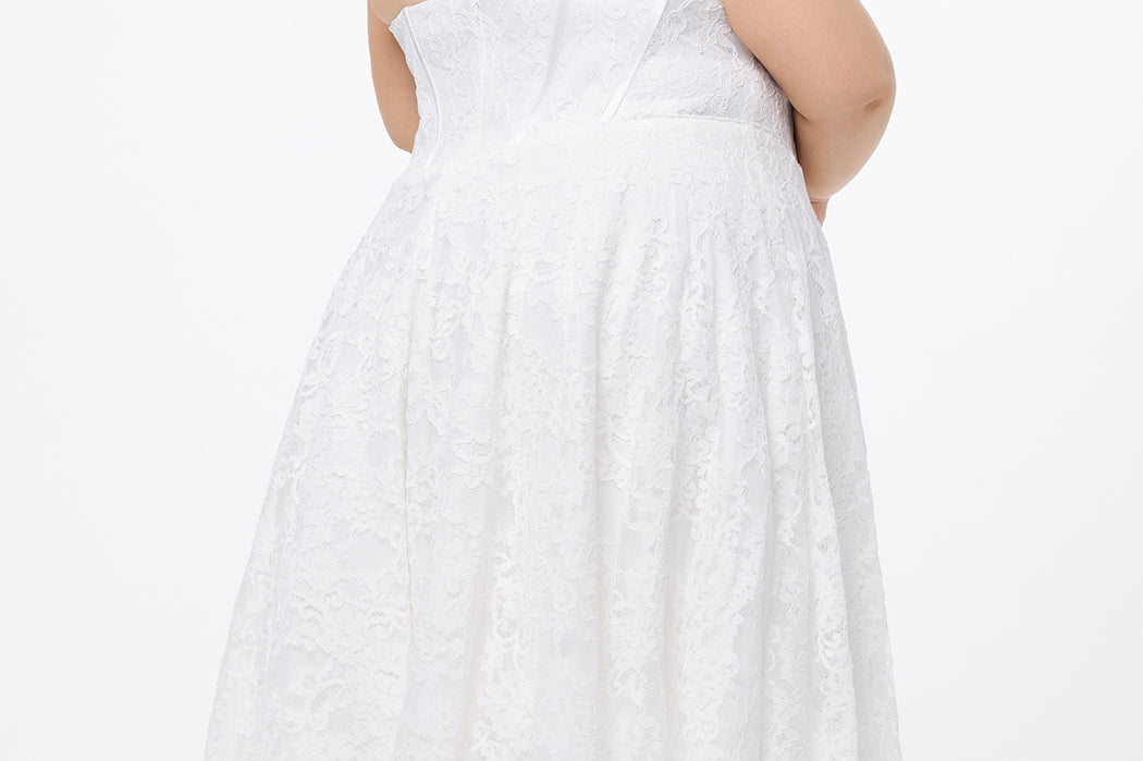 Celebrations by Sydney's Closet Style CE2613 in white. 

Plus size strapless white tea-length dress with sweetheart neckline, exposed corset boning on bustier bodice and tea-length skirt in all over stretch lace. 
