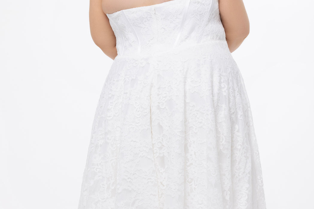 Celebrations by Sydney's Closet Style CE2613 in white. 

Plus size strapless white tea-length dress with sweetheart neckline, exposed corset boning on bustier bodice and tea-length skirt in all over stretch lace. 