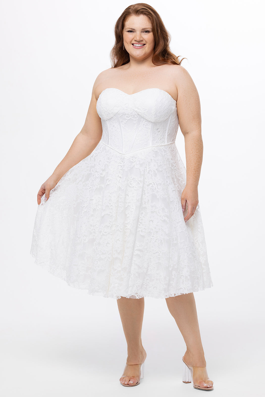 Celebrations by Sydney's Closet Style CE2613 in white. 

Plus size strapless white tea-length dress with sweetheart neckline, exposed corset boning on bustier bodice and tea-length skirt in all over stretch lace. 