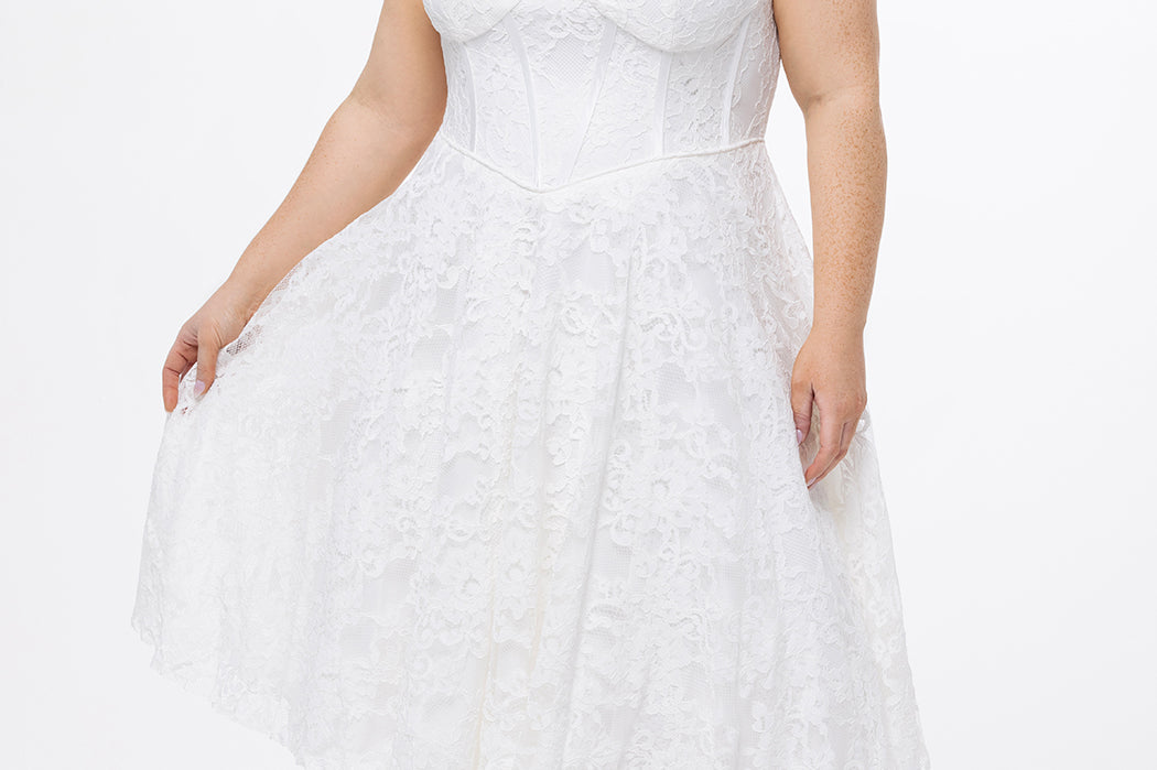 Celebrations by Sydney's Closet Style CE2613 in white. 

Plus size strapless white tea-length dress with sweetheart neckline, exposed corset boning on bustier bodice and tea-length skirt in all over stretch lace. 