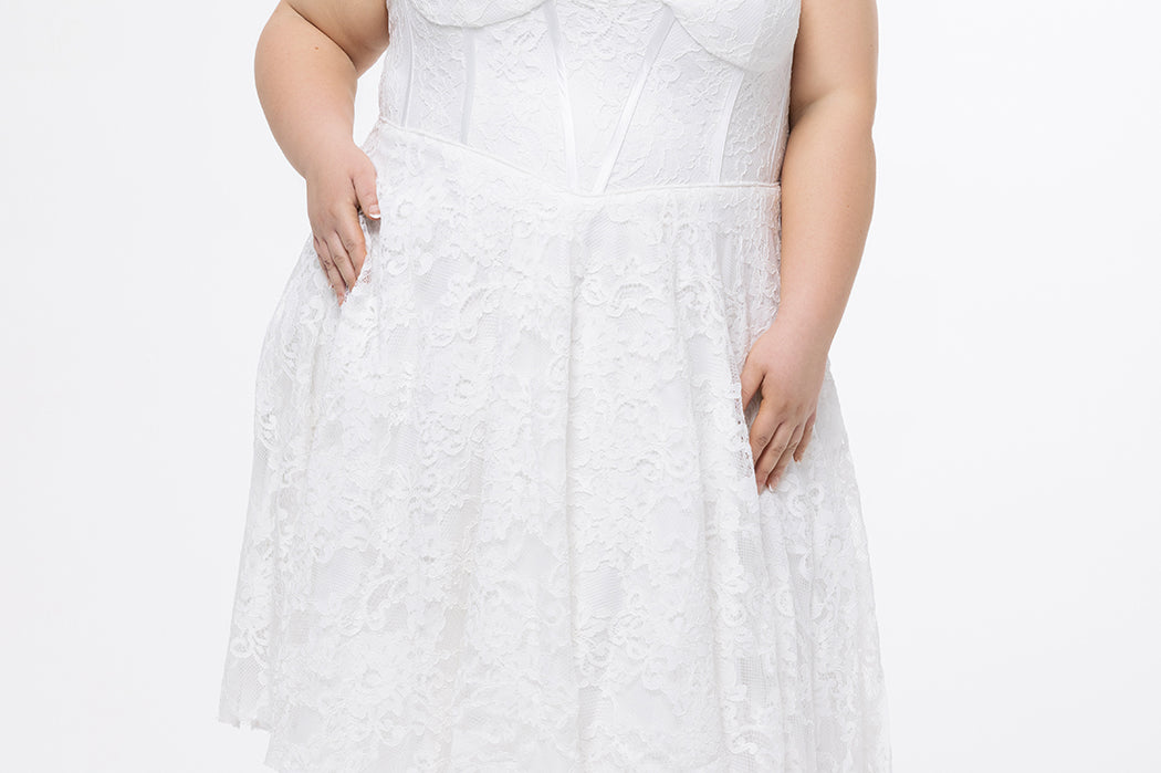 Celebrations by Sydney's Closet Style CE2613 in white. 

Plus size strapless white tea-length dress with sweetheart neckline, exposed corset boning on bustier bodice and tea-length skirt in all over stretch lace. 