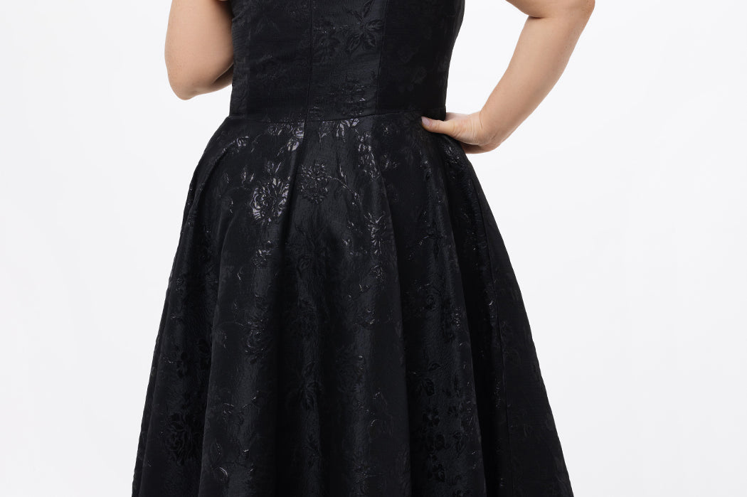 Celebrations by Sydney's Closet Style CE2614 in Black

Plus size maxi length formal dress. One-shoulder neckline with detachable bow at high point of shoulder, natural waistline and A-line skirt with pockets. 

Black floral brocade fabric. 
