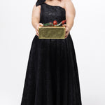 Celebrations by Sydney's Closet Style CE2614 in Black

Plus size maxi length formal dress. One-shoulder neckline with detachable bow at high point of shoulder, natural waistline and A-line skirt with pockets. 

Black floral brocade fabric. 

Shown with model holding a Christmas gift.
