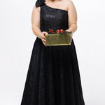 Celebrations by Sydney's Closet Style CE2614 in Black

Plus size maxi length formal dress. One-shoulder neckline with detachable bow at high point of shoulder, natural waistline and A-line skirt with pockets. 

Black floral brocade fabric. 

Shown with model holding a Christmas gift.