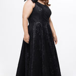 Celebrations by Sydney's Closet Style CE2614 in Black

Plus size maxi length formal dress. One-shoulder neckline with detachable bow at high point of shoulder, natural waistline and A-line skirt with pockets. 

Black floral brocade fabric. 