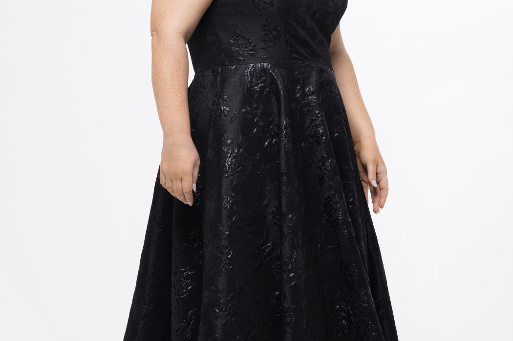 Celebrations by Sydney's Closet Style CE2614 in Black

Plus size maxi length formal dress. One-shoulder neckline with detachable bow at high point of shoulder, natural waistline and A-line skirt with pockets. 

Black floral brocade fabric. 