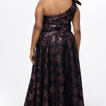 Celebrations by Sydney's Closet Style CE2614 in Pink Rose and Black floral brocade fabric.

Plus size maxi length formal dress. One-shoulder neckline with detachable bow at high point of shoulder, natural waistline and A-line skirt with pockets. 