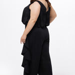 Celebrations by Sydney's Closet Style CE2615 in Black.

One-piece crepe satin jumpsuit with ruffled on outer pants seams. Bra-friendly straps, blouson bodice and wide leg pants. Center back zipper and scoop neckline. 