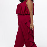 Celebrations by Sydney's Closet Style CE2615 in cherry red.

One-piece crepe satin jumpsuit with ruffled on outer pants seams. Bra-friendly straps, blouson bodice and wide leg pants. Center back zipper and scoop neckline. 