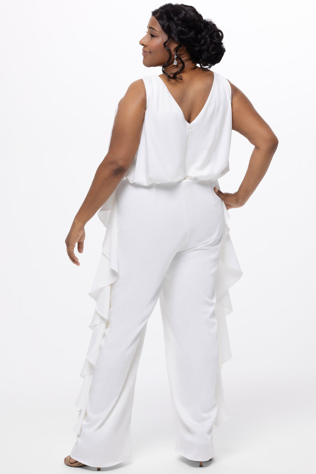 Celebration's by Sydney's Closet style CE2615 in Ivory. 

Crepe satin jumpsuit with a V-neck, bra-friendly straps, wide leg pants and blouson bodice. Ruffle detail on outer seams of pants. V-back with long center back zipper. 