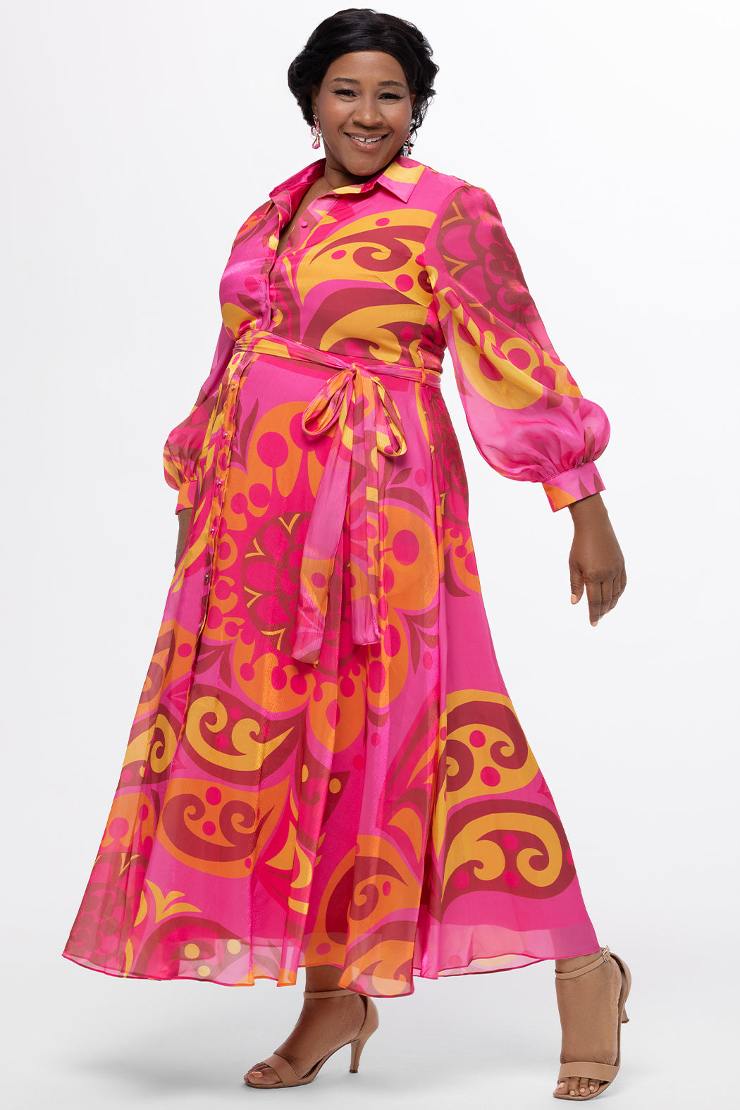 Celebration's by Sydney's Closet style CE2622 in abstract print. 

Button down plus size ankle length gown made from printed organza. V-neck, long pouf sleeves with cuff and optional belt. A-line skirt with pockets.