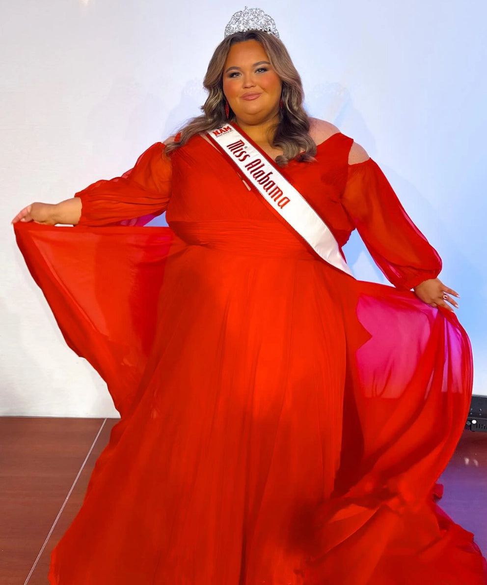 Woman in a red gown with a sash reading "Miss Alabama" and tiara, posing on a stage.