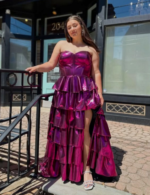 Woman in a pink strapless gown standing at the top of outdoor patio stairs.