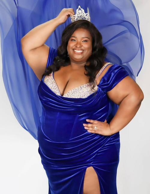 Woman in a blue evening gown with a tiara against a white background