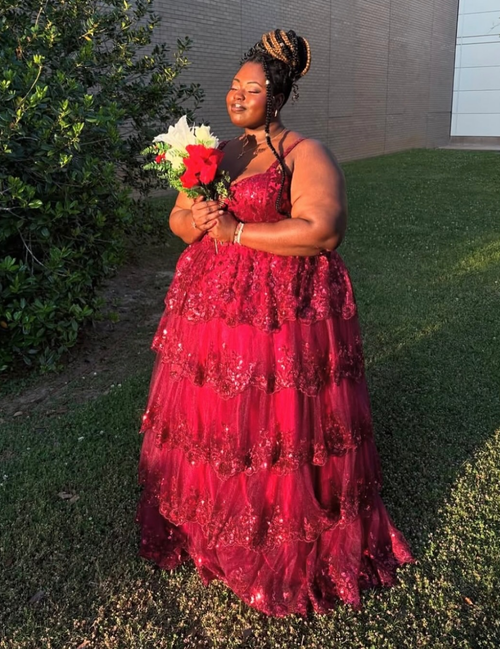 Woman in a red dress holding flowers outdoors