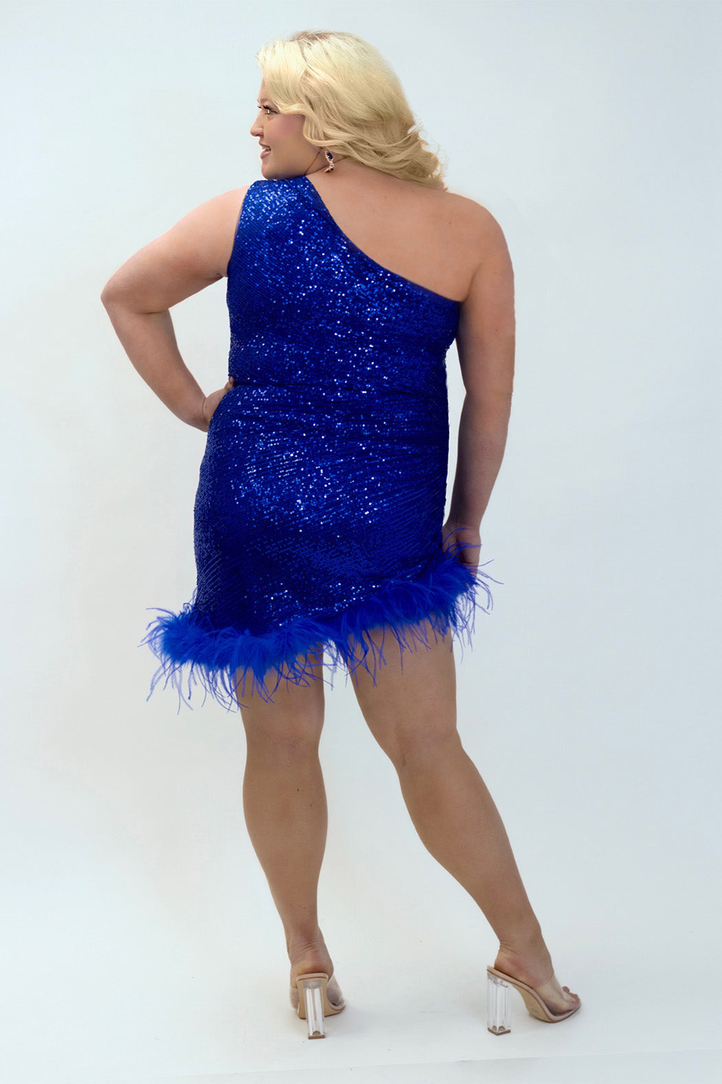 This is JK2401 in our collection Johnathan Kayne for Sydney's Closet. This plus size party dress comes in blue, red, black and white. This dress is one shoulder, all over sequins, an asymmetrical skirt, and has a feather hem.