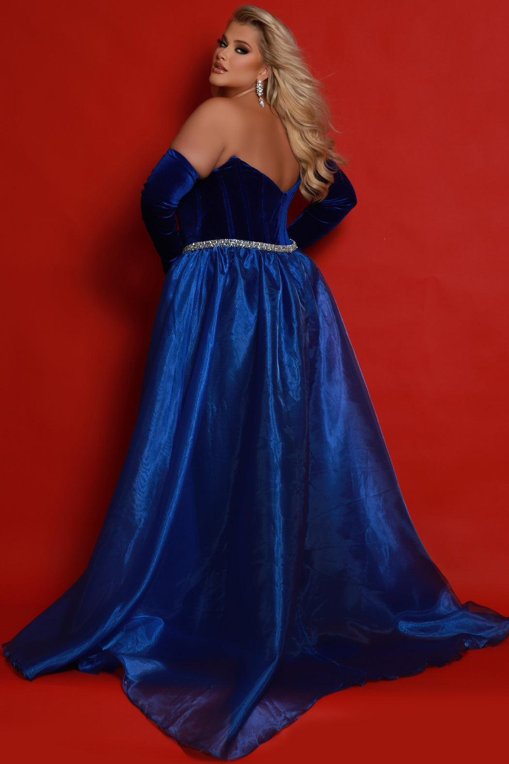 Johnathan Kayne for Sydney's Closet JK2418 Royal. Slim/Fitted silhouette, Sweetheart bodice, Strapless, Optional 1 inch straps, Optional evening gloves, Bustier exposed boning corset on front and back bodice, Detachable overskirt, Studded waistline Hook & eye into dress, Basque waistline, V-back, Long invisible center back zipper, Slim skirt with slit, natural waistline, Sweep train.