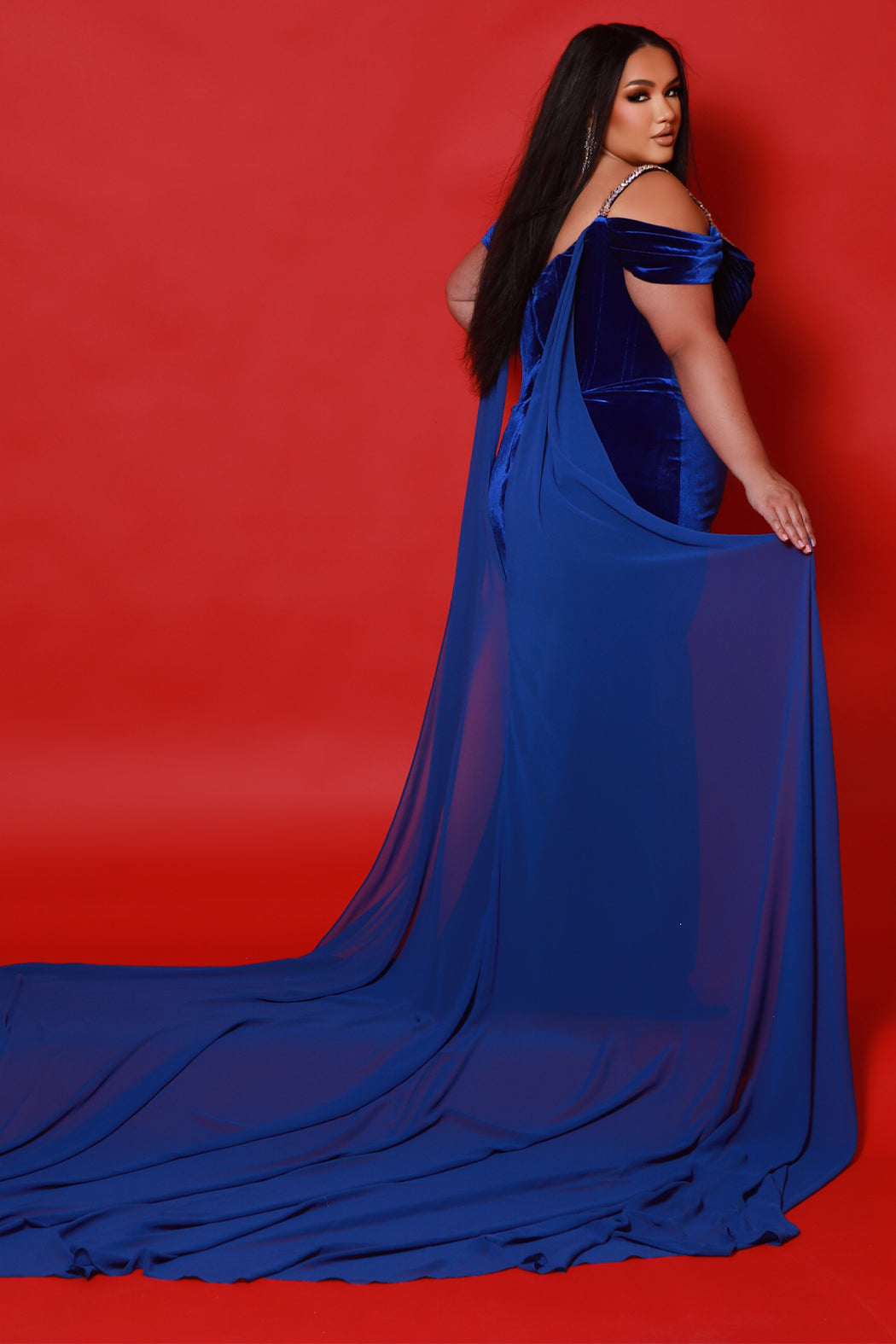 Johnathan Kayne for Sydney's Closet plus size pageant gown. Style JK2514 in stretch velvet with beaded bustier bodice and optional chiffon cape. Pleated drape on bodice with pleated detachable drape sleeves.  Exposed corset boning with basque waistline. Slim fitted skirt with ruching and high slit.  Availablie in forest green, onyx black or royal blue in plus sizes 10-24.