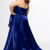 Johnathan Kayne for Sydney's Closet style JK2608.

Strapless sweetheart plus size A-line gown.  Ruched bodice with bow at natural waistline and flounce down left leg slit. Shiny organza fabric for lightweight comfort. Available in sizes  10-32 in Red, Black and Blue. 