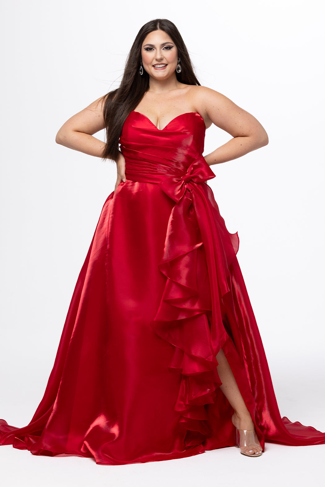 Johnathan Kayne for Sydney's Closet style JK2608.

Strapless sweetheart plus size A-line gown.  Ruched bodice with bow at natural waistline and flounce down left leg slit. Shiny organza fabric for lightweight comfort. Available in sizes  10-32 in Red, Black and Blue. 