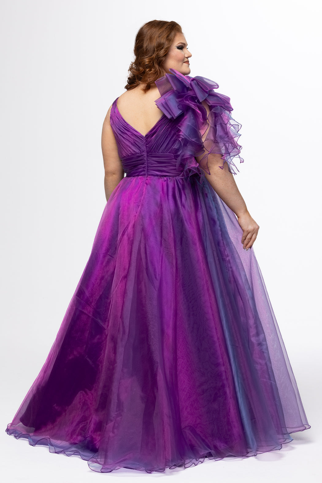 Johnathan Kayne for Sydney's Closet style JK2611. 

Plus size A-line gown made with multidimensional organza. Thick straps with detachable ruffle at shoulder. Ruched waistband with natural waistline and left leg slit with large ruffle. Deep v-neckline and center back zipper. Available in sizes 10-32 in purple and red. 