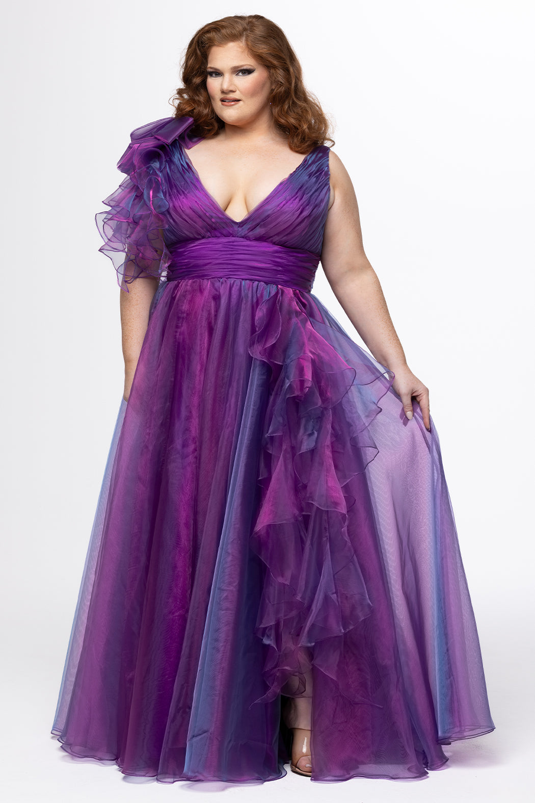 Johnathan Kayne for Sydney's Closet style JK2611. 

Plus size A-line gown made with multidimensional organza. Thick straps with detachable ruffle at shoulder. Ruched waistband with natural waistline and left leg slit with large ruffle. Deep v-neckline and center back zipper. Available in sizes 10-32 in purple and red. 