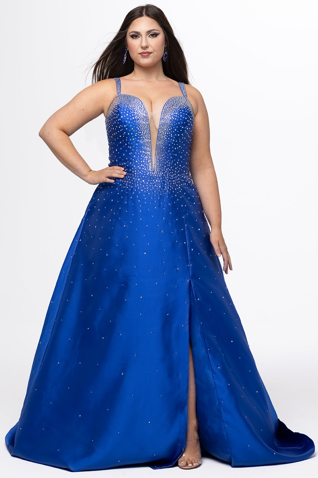 Johnathan Kayne for Sydney's Closet style JK2613. 

Plus size A-line gown with hot fix stones on thick satin fabric. Heavily embellished deep V-neckline with nude-mesh insert and embellished one inch straps. A-line skirt with left leg slit. Lace up back with modesty panel and half zipper. Available in sizes 10-32 in red, blue and black. 