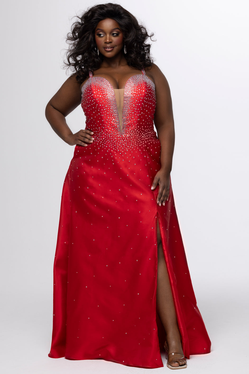 Johnathan Kayne for Sydney's Closet style JK2613. 

Plus size A-line gown with hot fix stones on thick satin fabric. Heavily embellished deep V-neckline with nude-mesh insert and embellished one inch straps. A-line skirt with left leg slit. Lace up back with modesty panel and half zipper. Available in sizes 10-32 in red, blue and black. 