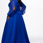 Johnathan Kayne for Sydney's Closet style JK2614. 

Plus size A-line chiffon gown with long bishop sleeves, beaded cuff and bicep slit. Bra-friendly straps, v-neckline and pleated bodice. Natural waistline with 4 inch beaded, rhinestone and sequin embellished waistband. Pockets, left leg slit with zipper, v-back and center back zipper. Available in sizes 10-32 in black, blue and red. 