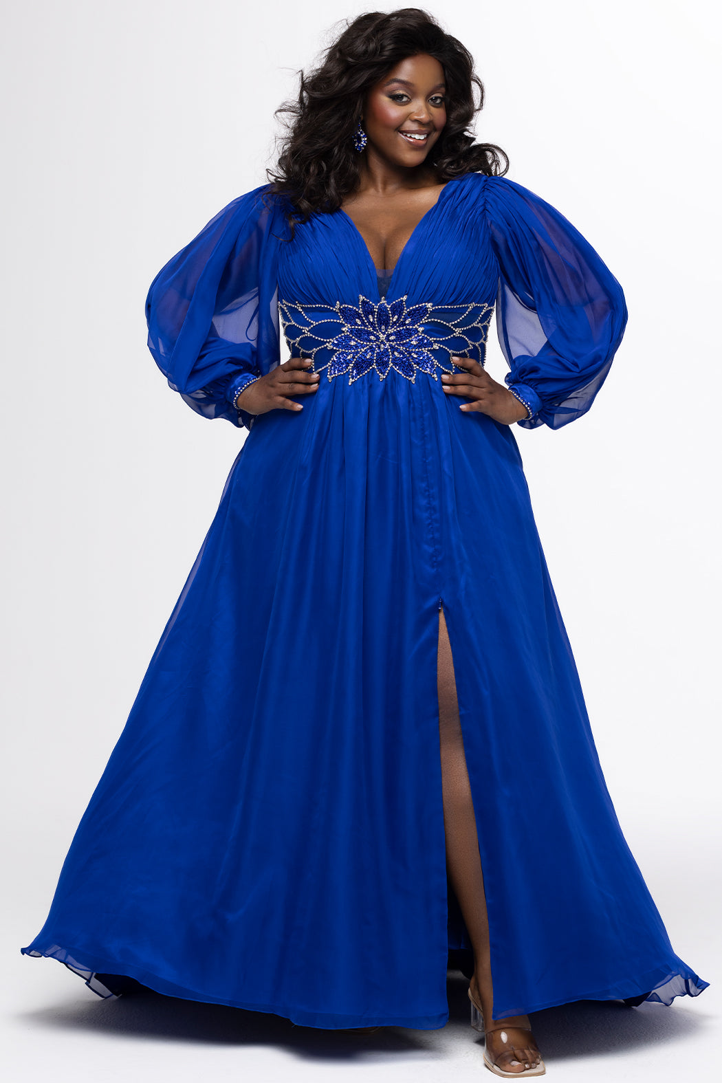 Johnathan Kayne for Sydney's Closet style JK2614. 

Plus size A-line chiffon gown with long bishop sleeves, beaded cuff and bicep slit. Bra-friendly straps, v-neckline and pleated bodice. Natural waistline with 4 inch beaded, rhinestone and sequin embellished waistband. Pockets, left leg slit with zipper, v-back and center back zipper. Available in sizes 10-32 in black, blue and red. 