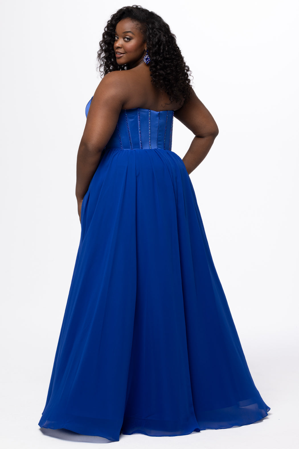 Johnathan Kayne for Sydney's Closet style JK2616. 

Strapless sweetheart plus size evening gown. Exposed bones covered in hot fix stones. Basque waist, chiffon A-line skirt, pockets, and left leg slit. Center back zipper. Available in sizes 10-32 in blue, black and red. 