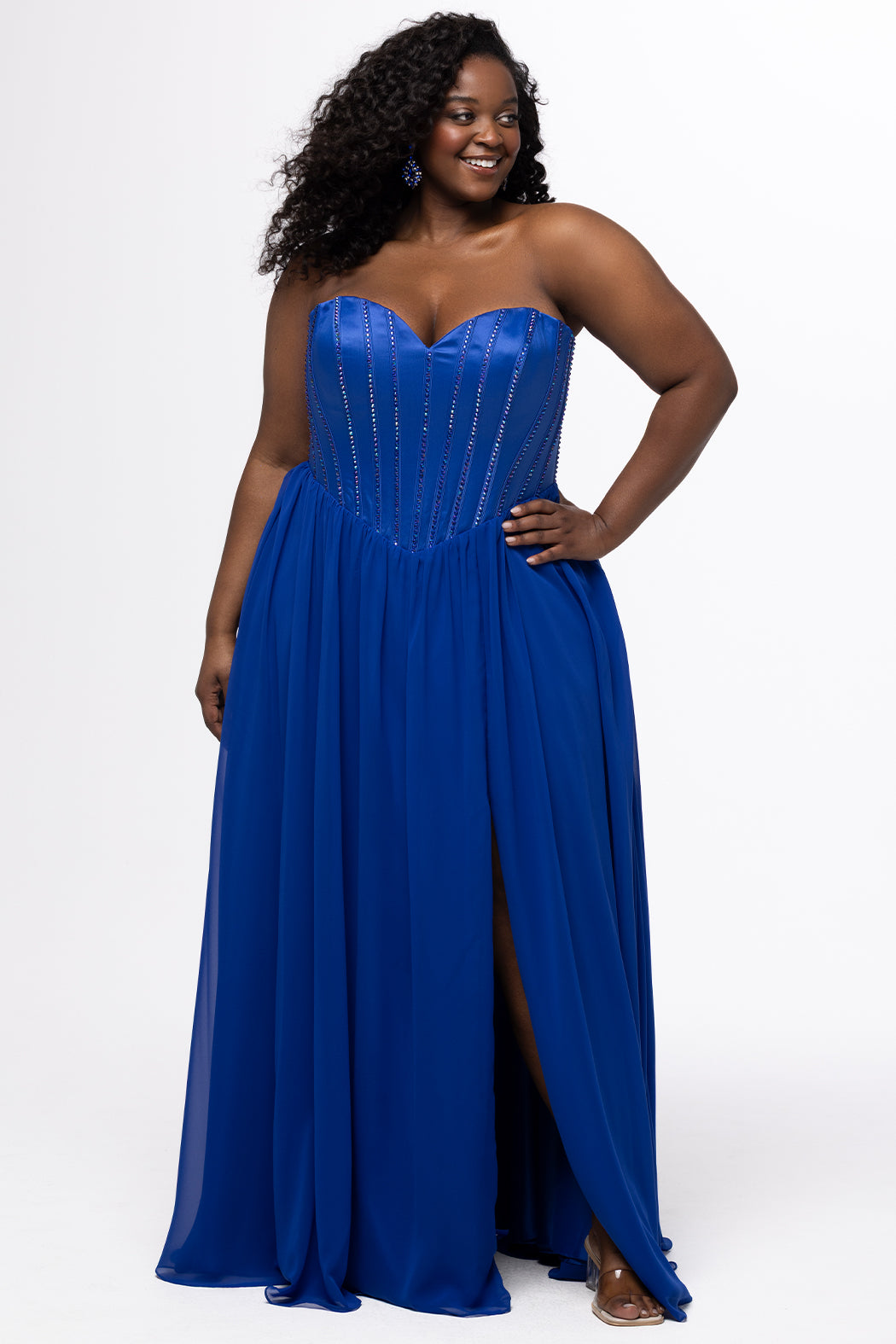 Johnathan Kayne for Sydney's Closet style JK2616. 

Strapless sweetheart plus size evening gown. Exposed bones covered in hot fix stones. Basque waist, chiffon A-line skirt, pockets, and left leg slit. Center back zipper. Available in sizes 10-32 in blue, black and red. 