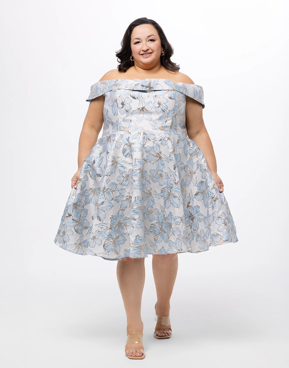 Woman wearing a blue floral off-shoulder dress on a white background