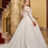 Michelle Bridal MB2424 Ivory. Embroidered lace appliques on mesh, Bridal tulle, sparkle tulle, Light lining, Leaf lace appliques, clear sequins, cut glass, Ballgown silhouette, High Neckline, Collar = 1 inch beaded appliques, Illusion bodice covered in beaded appliques, Sweetheart lining, Long sleeves covered in appliques with sequins, Closure at wrist = covered buttons with elastic loops, V-back, Invisible center back zipper.