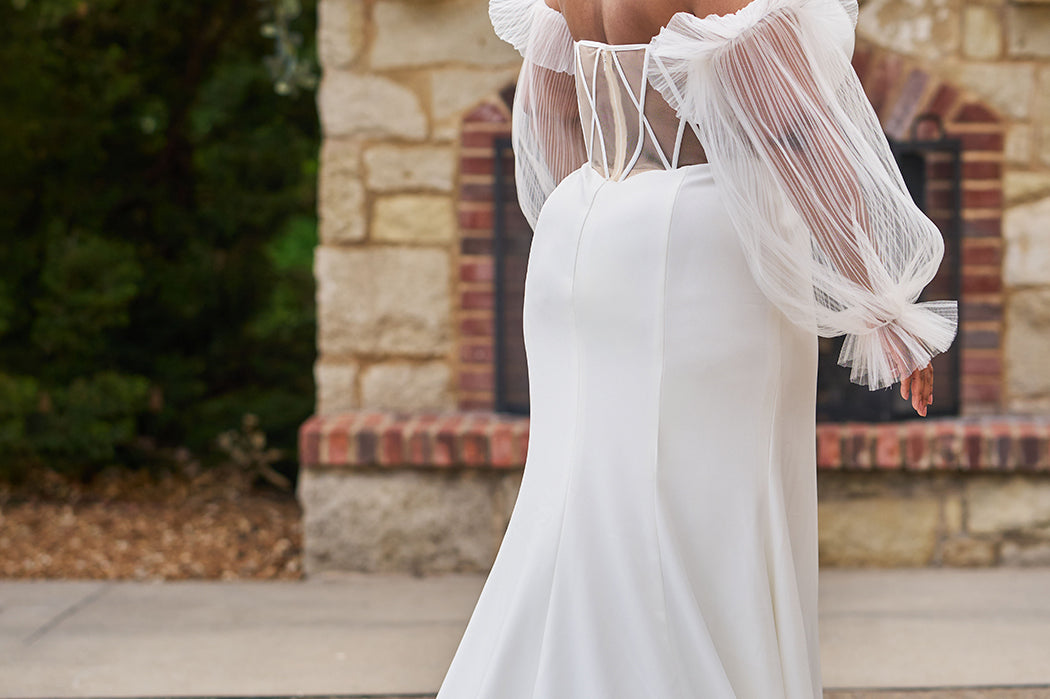 Sophisticated and sexy plus size simple crepe wedding dress with detachable puff sleeves.  Plain crepe slim front with sweetheart neckline and natural waist.  Optional lining included for the back bodice with criss-cross exposed boning.  Michelle Bridal by Sydney's Closet style MB2522