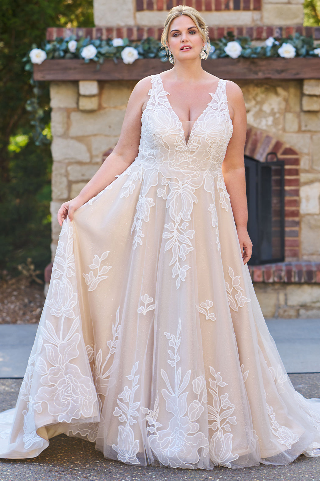 Plus size A-line oversized floral weding dress in ivory or champagne. Style MB2525 from Michelle Bridal by Sydney's Closet has illusions straps covered in appliques, natural waisltine, long flowy A-line skirt and long train with covered buttons. 