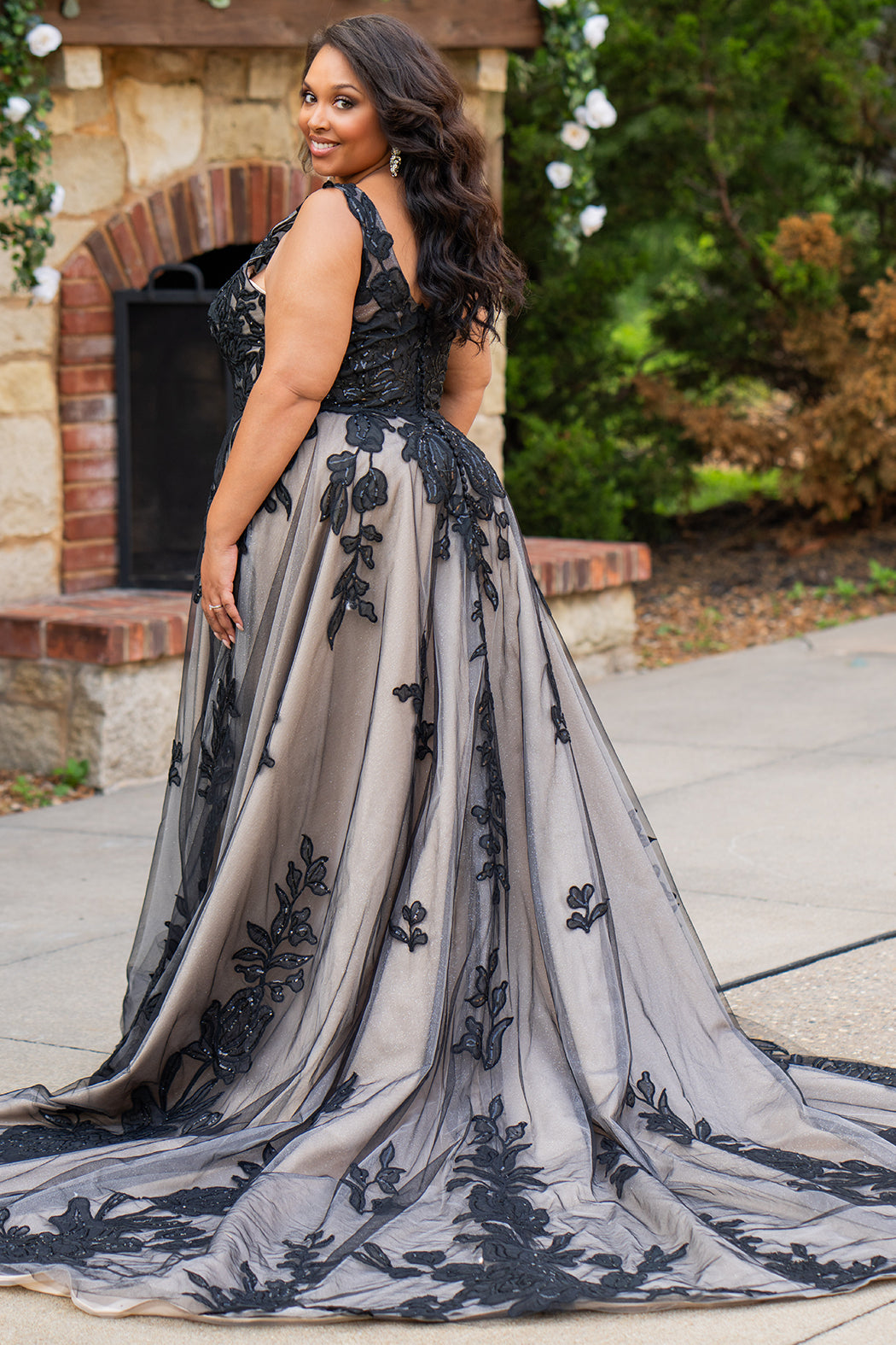 Plus size A-line oversized floral weding dress in black, ivory or champagne. Style MB2525 from Michelle Bridal by Sydney's Closet has illusions straps covered in appliques, natural waisltine, long flowy A-line skirt and long train with covered buttons. 