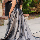 Plus size A-line oversized floral weding dress in black, ivory or champagne. Style MB2525 from Michelle Bridal by Sydney's Closet has illusions straps covered in appliques, natural waisltine, long flowy A-line skirt and long train with covered buttons. 