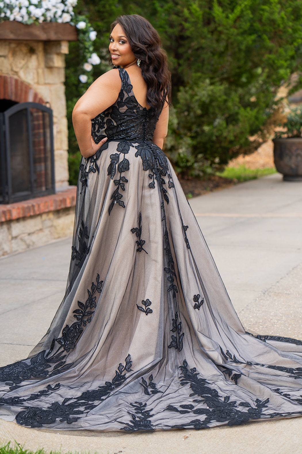 Plus size A-line oversized floral weding dress in black, ivory or champagne. Style MB2525 from Michelle Bridal by Sydney's Closet has illusions straps covered in appliques, natural waisltine, long flowy A-line skirt and long train with covered buttons. 