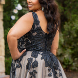 Plus size A-line oversized floral weding dress in black, ivory or champagne. Style MB2525 from Michelle Bridal by Sydney's Closet has illusions straps covered in appliques, natural waisltine, long flowy A-line skirt and long train with covered buttons. 