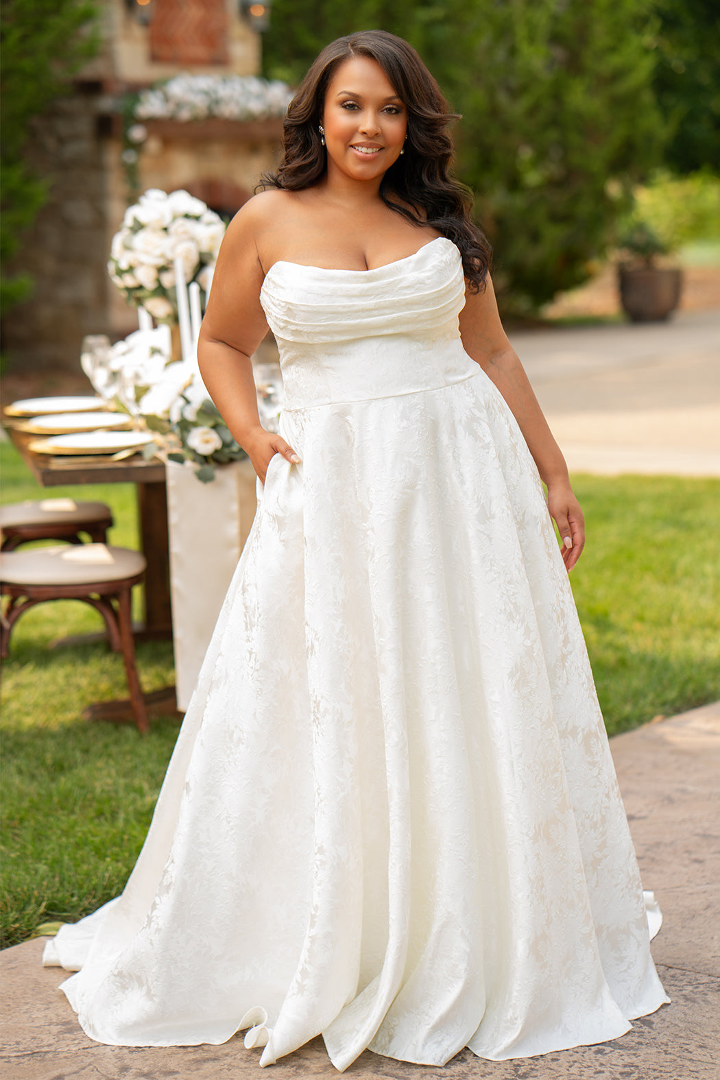 Michelle Bridal MB2601 in Buttercream. Soft brocade fabric, strapless bodice with pleated drape detail, natural waistline and A-line skirt. Pockets and center back zipper. 