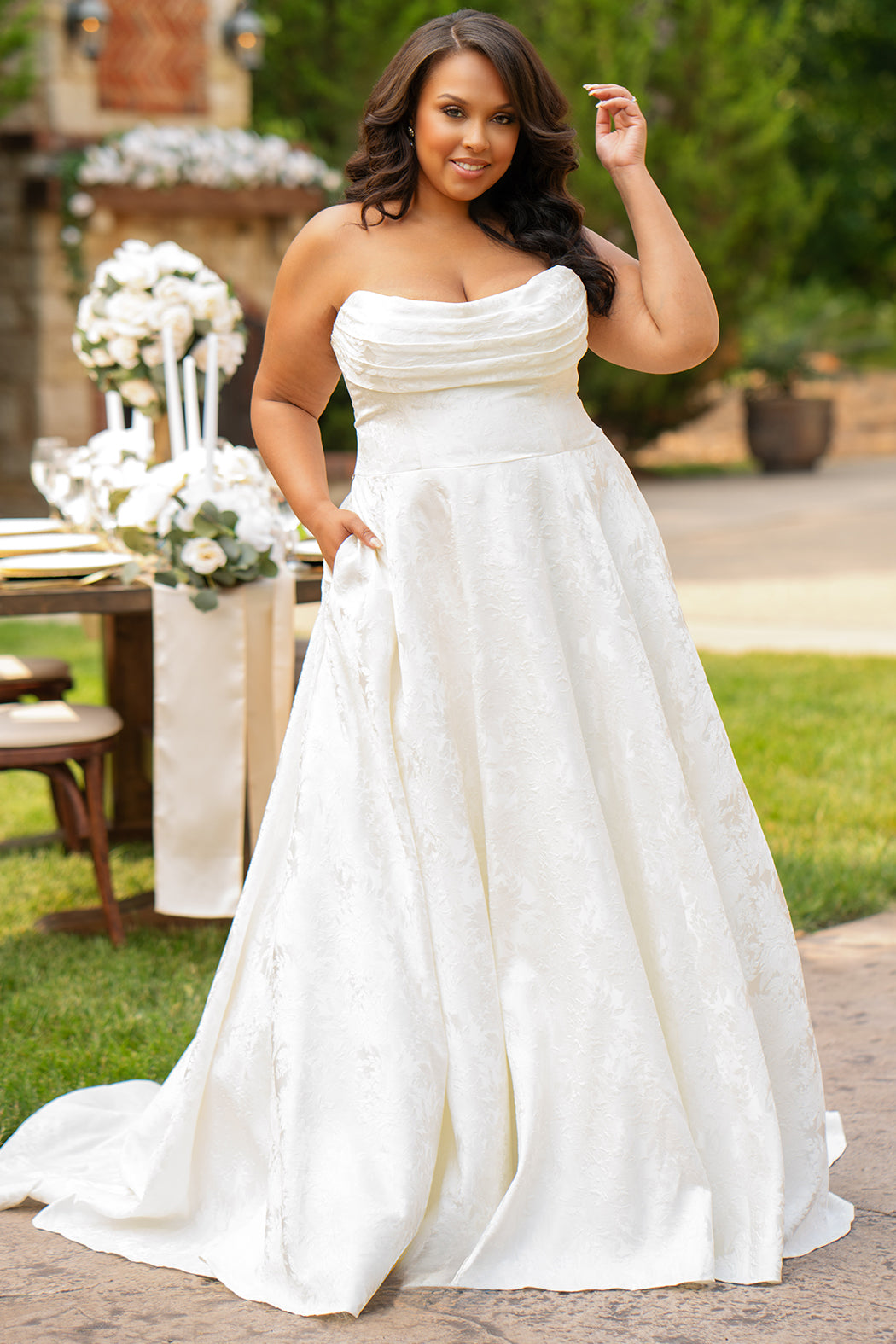 Michelle Bridal MB2601 in Buttercream. Soft brocade fabric, strapless bodice with pleated drape detail, natural waistline and A-line skirt. Pockets and center back zipper. 